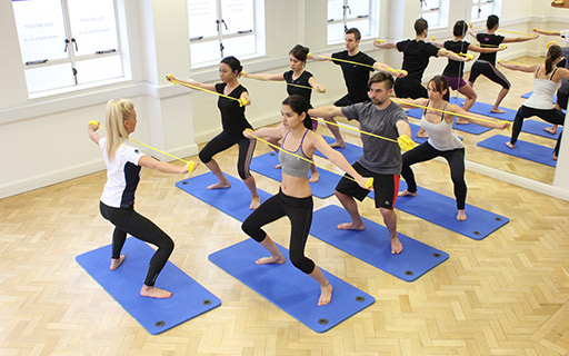 Pilates instructing a group pilates class Pilates instructing a group pilates class