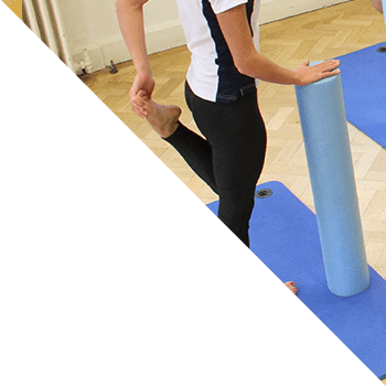 Instructor shows class how to use foam rollers during stretch excercises