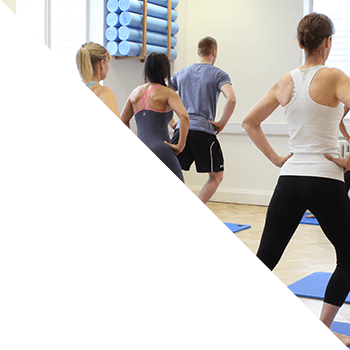 Pilates class completing simple warmup stretches