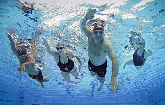 Unwater view of a man swimming in an Olympic pool.